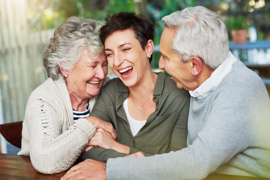 Woman with both her aging parents hugging
